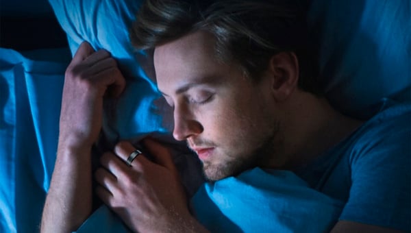 person sleeping with a smart ring on their finger