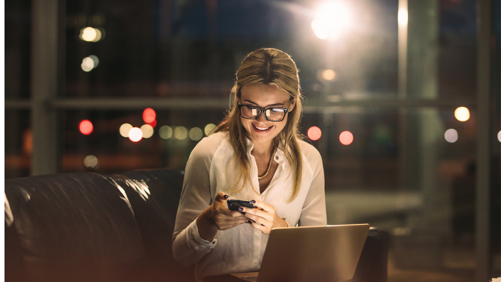 Young woman with smart lights looking at telephone