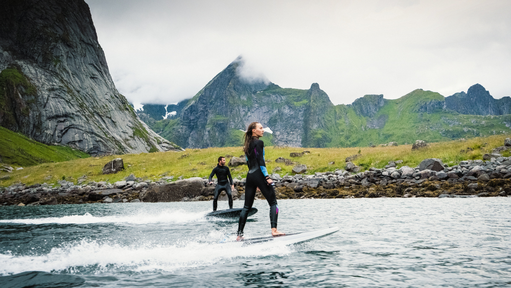 Man woman surfing background mountains. Image source: Radinn